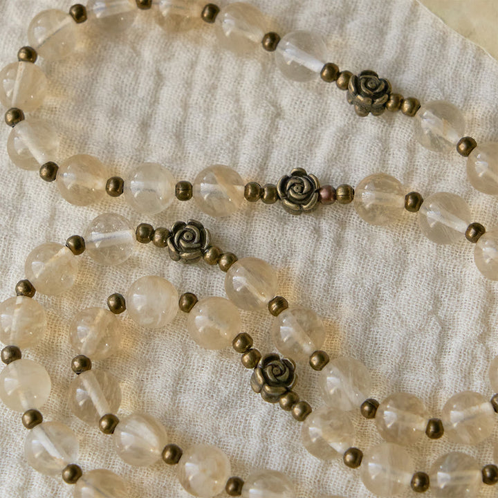Christianartworkshop Rosario con perle di vetro ambrato e decorazioni a forma di camelia: simbolo della luce e della purezza di Cristo. - image 4