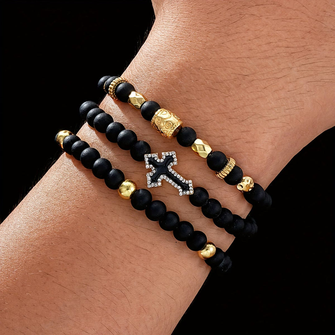 Christianartworkshop Bracciale elastico multistrato con perline di pietra nera opaca, croce con zirconi incastonati e distanziatori in oro intagliato. - Bracciale a 3 pezzi - image 0