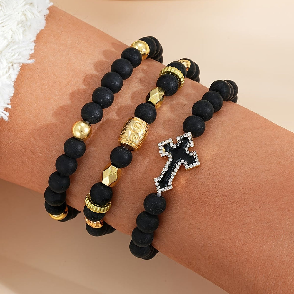 Christianartworkshop Bracciale elastico multistrato con perline di pietra nera opaca, croce con zirconi incastonati e distanziatori in oro intagliato. - image 1
