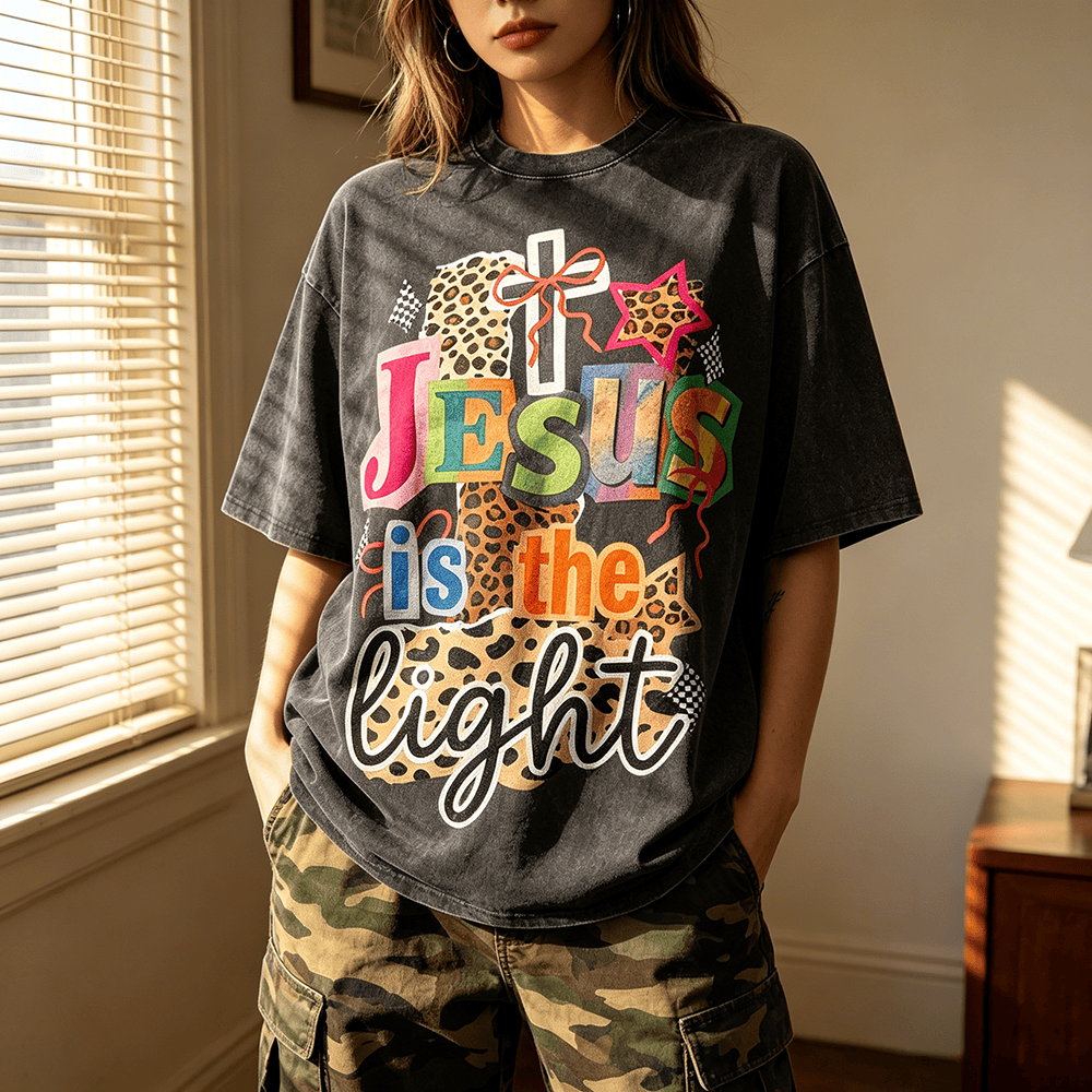 Christianartworkshop T-shirt unisex lavata con grafica leopardata, croce, fiocco e stella "Jesus Is The Light". - image 0