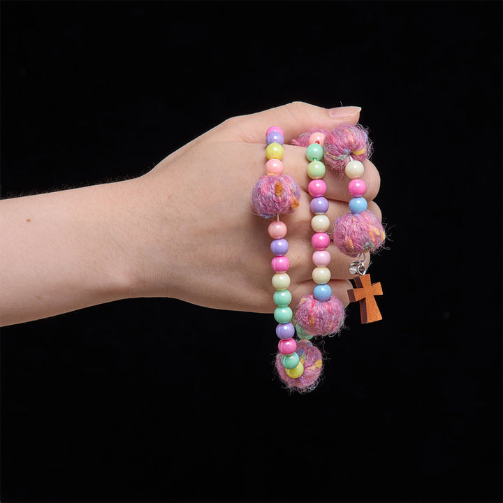 Christianartworkshop Rosario per bambini con perline a forma di macaron e pompon soffici, con croce in legno: emblema di innocente gentilezza celeste. - image 1