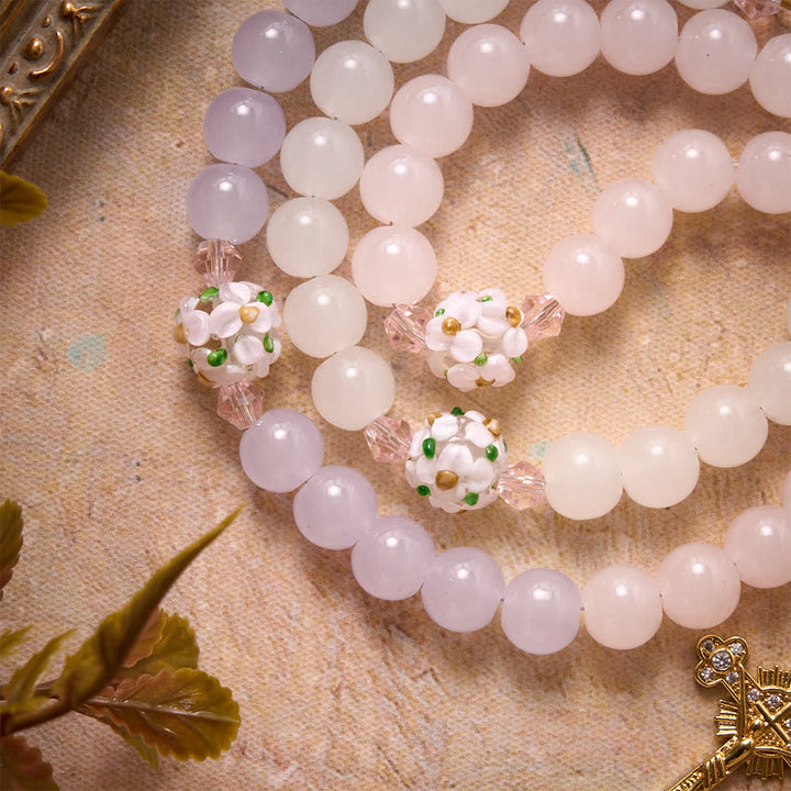 Christianartworkshop Rosario con perline di vetro a motivi floreali, sfumature di rosa, lavanda e bianco latte, croce con strass e medaglione della Madonna. - image 6